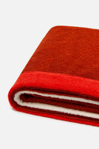 Close-up of a folded red and brown fabric on a white background
