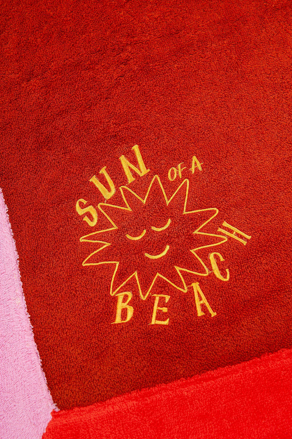 Red towel with yellow sun design and text on a red background