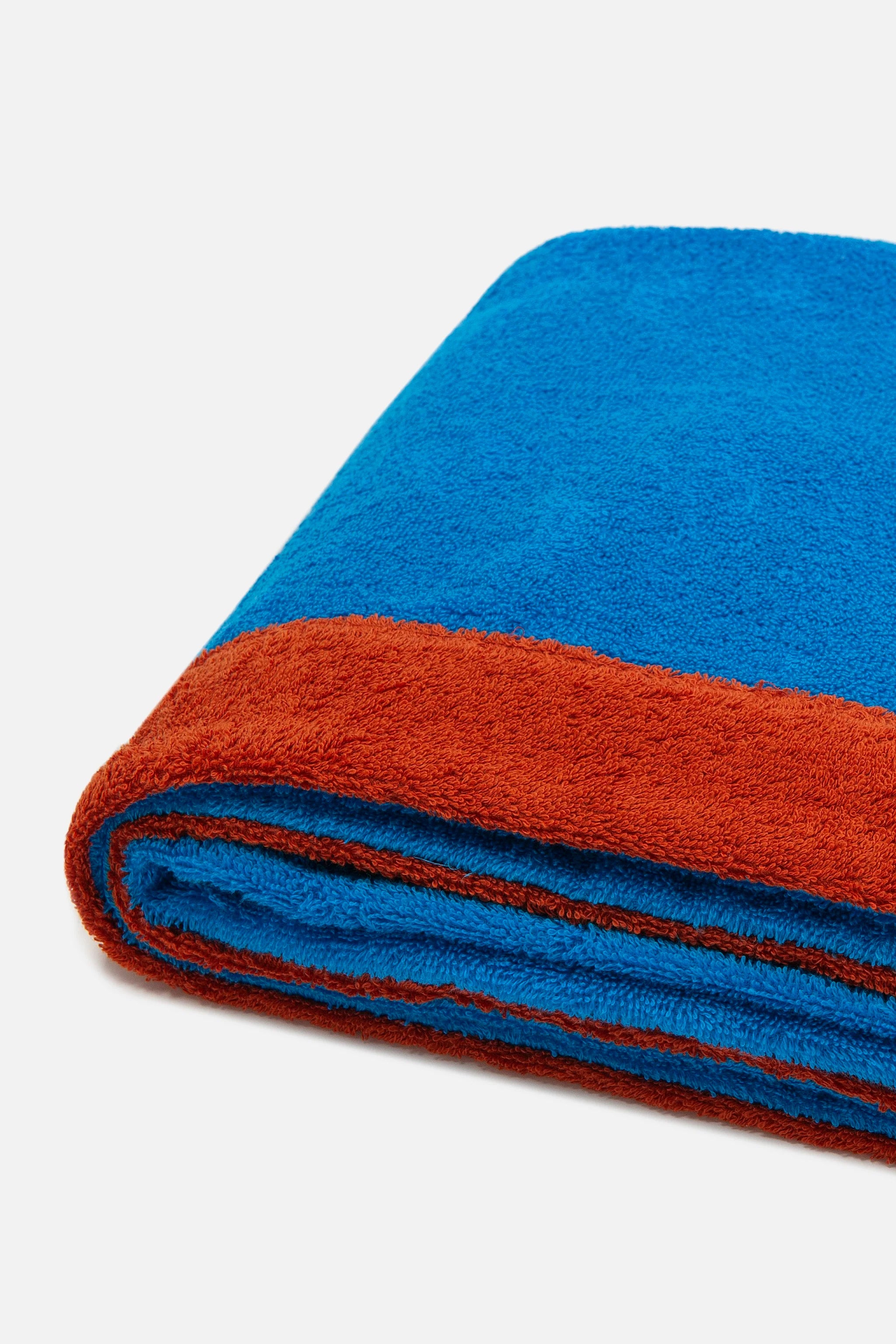 Folded blue and red towel on a light gray background