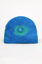 Blue towel with green eye design on a white background