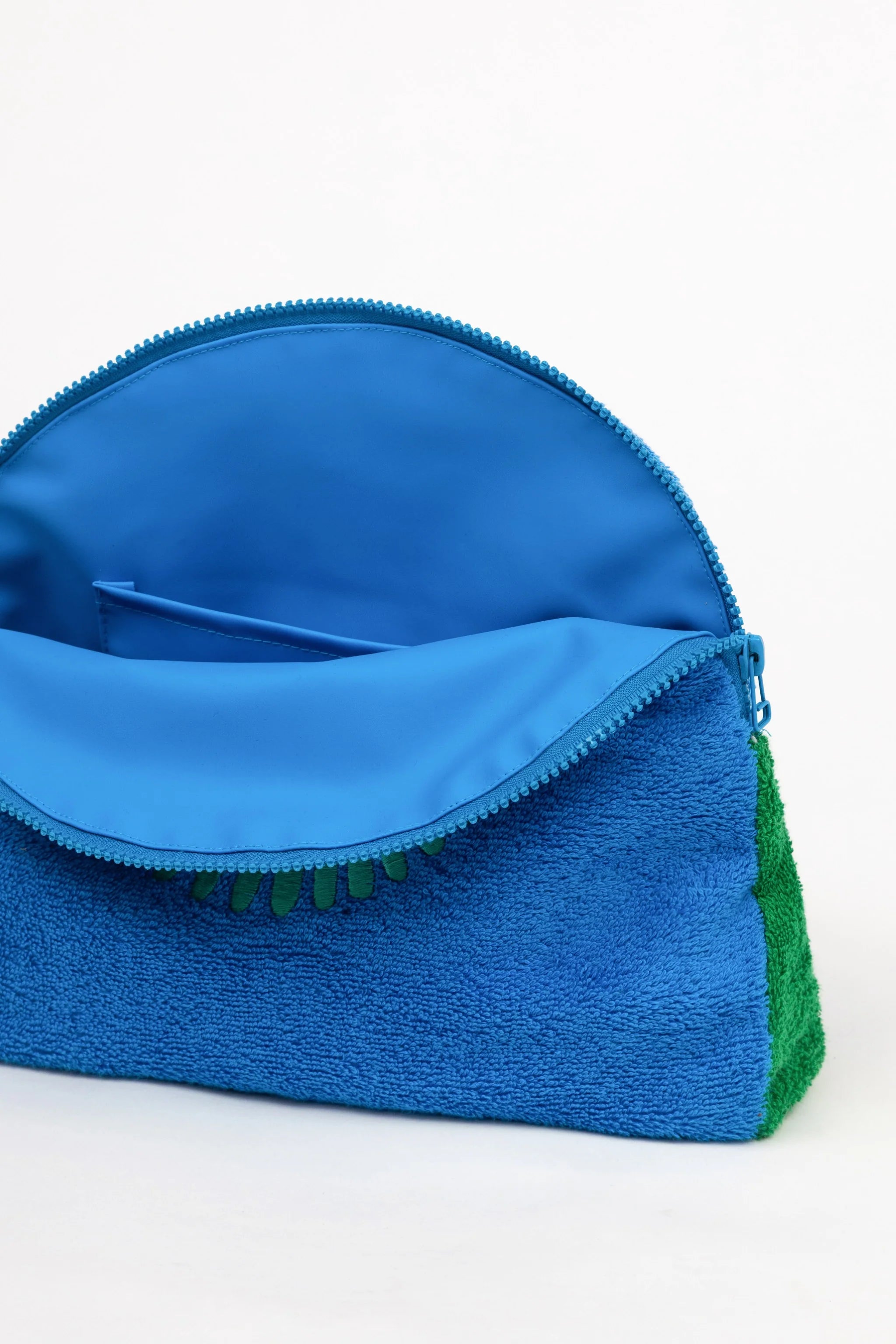 Blue textured pouch with a green base on a white background