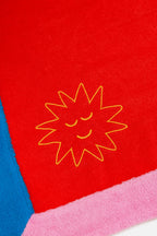 Red towel with a yellow sun design on a white background