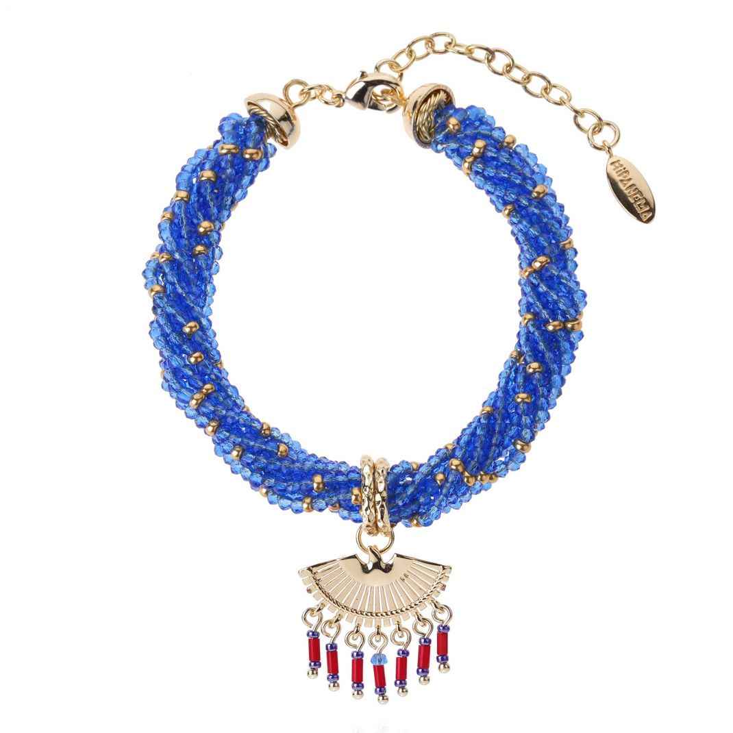 Blue beaded bracelet with gold and red pendant on a white background