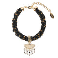Black beaded bracelet with gold accents and a decorative charm on a white background