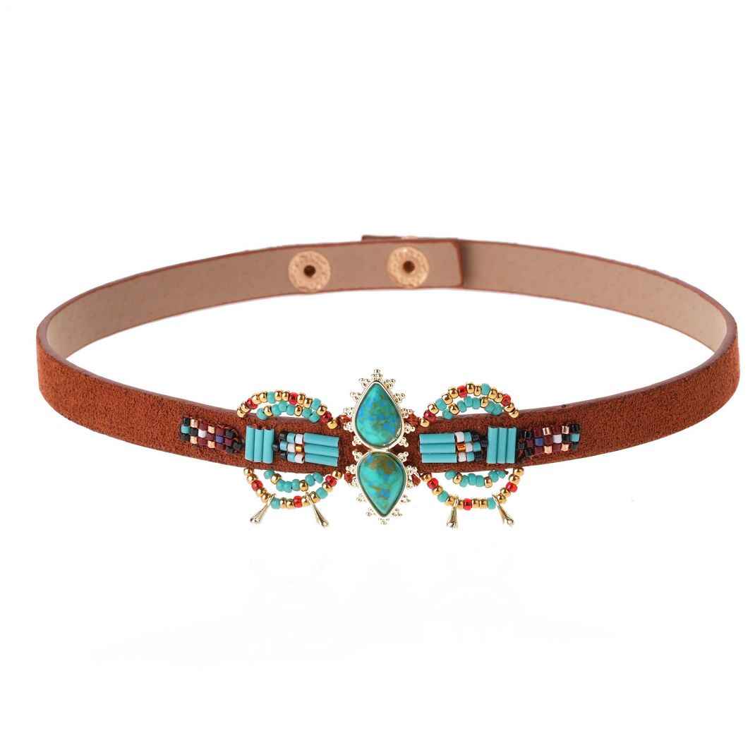 Decorative belt with turquoise and gold bow design on a white background