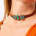 Necklace with turquoise stones and brown leather strap worn by a person