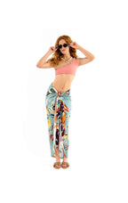 Woman wearing a colorful sarong and pink top on a white background
