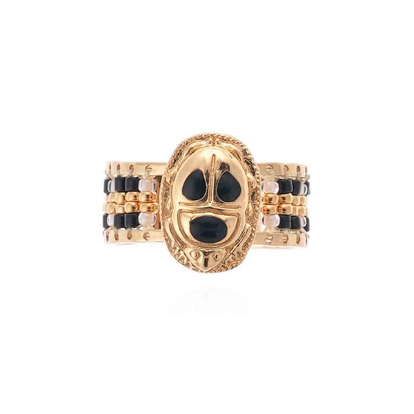 Gold ring with black and white accents on a white background