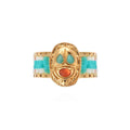 Gold ring with turquoise and coral accents on a white background