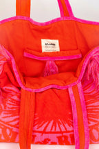 Red and pink tie-dye bag with a visible brand label on a white background