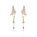 Gold and pearl drop earrings on a white background