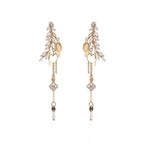 Gold and pearl drop earrings on a white background