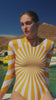 Andreakou Concept Store summer fashion video — woman in yellow striped swimsuit by the sea