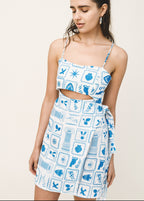 Woman wearing a blue and white patterned dress on a plain background