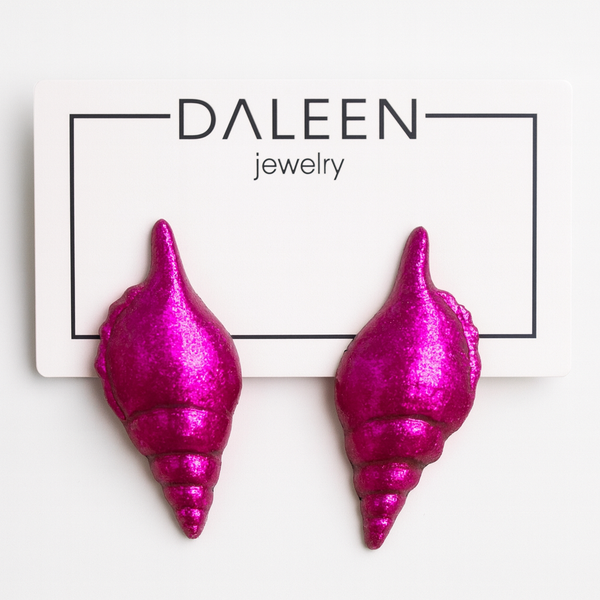 Pink shell-shaped earrings on a Daleen Jewelry card.