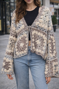 Person wearing a patterned cardigan with a blurred urban background