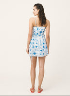 Woman wearing a blue and white patterned dress on a white background