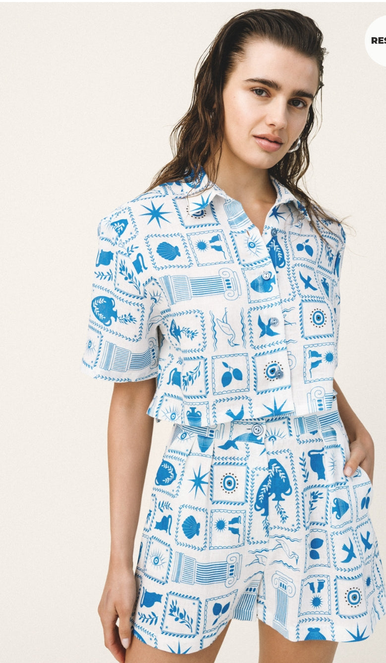 Woman wearing a blue and white patterned outfit on a plain background