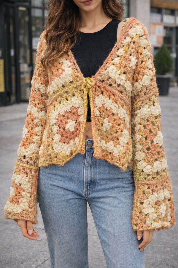 Person wearing a colorful crochet cardigan with jeans outdoors
