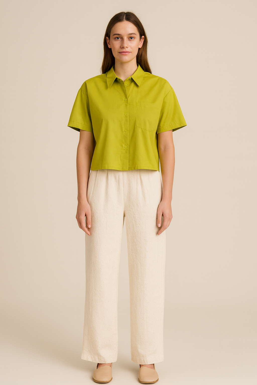 Woman wearing a green shirt and white pants on a beige background