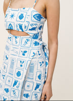 White dress with blue geometric patterns on a plain background