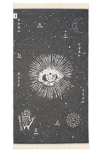 Towel with celestial design featuring an eye, hand, and geometric patterns on a dark background.