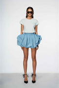 Woman wearing a white t-shirt and blue skirt on a white background