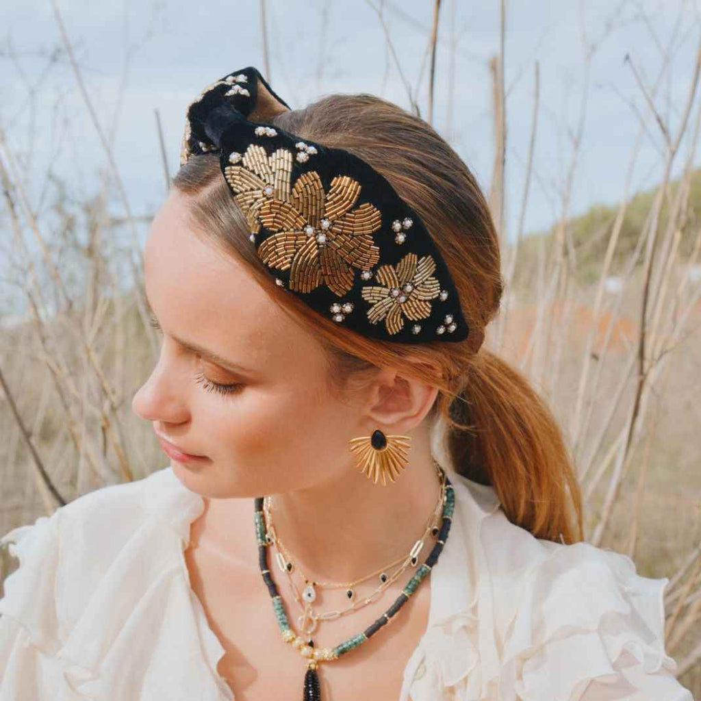Woman wearing a decorative headband and earrings in a natural setting