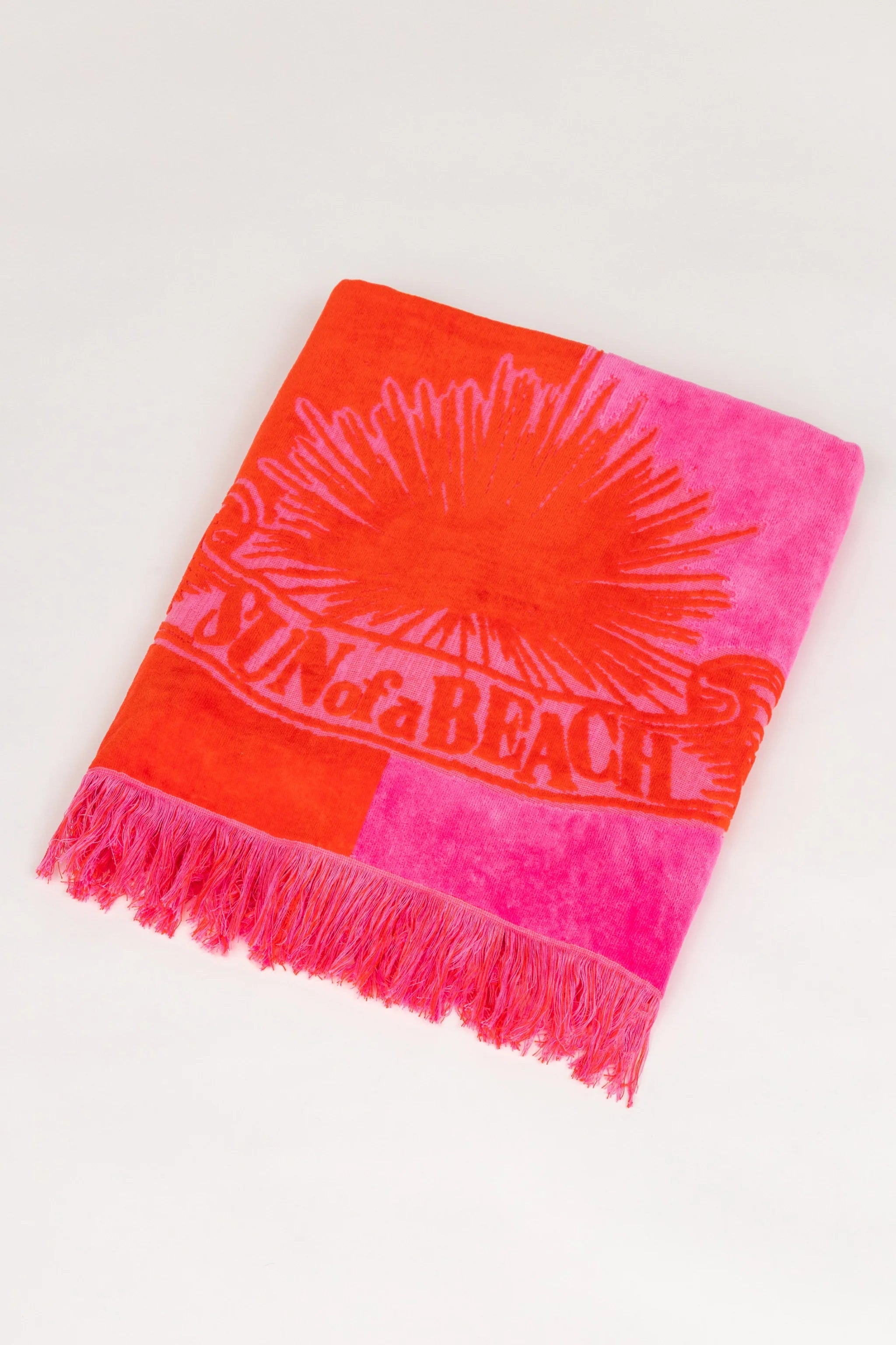 Two-toned orange and pink beach towel with branding on a white background