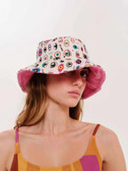 Woman wearing a colorful bucket hat with a white background