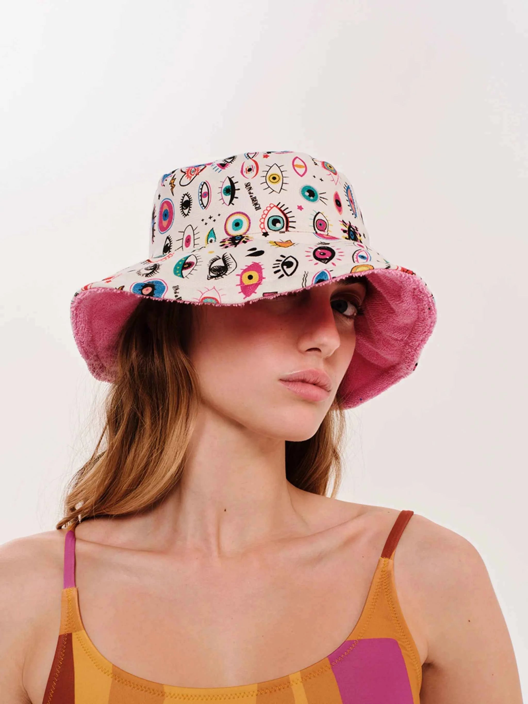 Woman wearing a colorful bucket hat with a white background