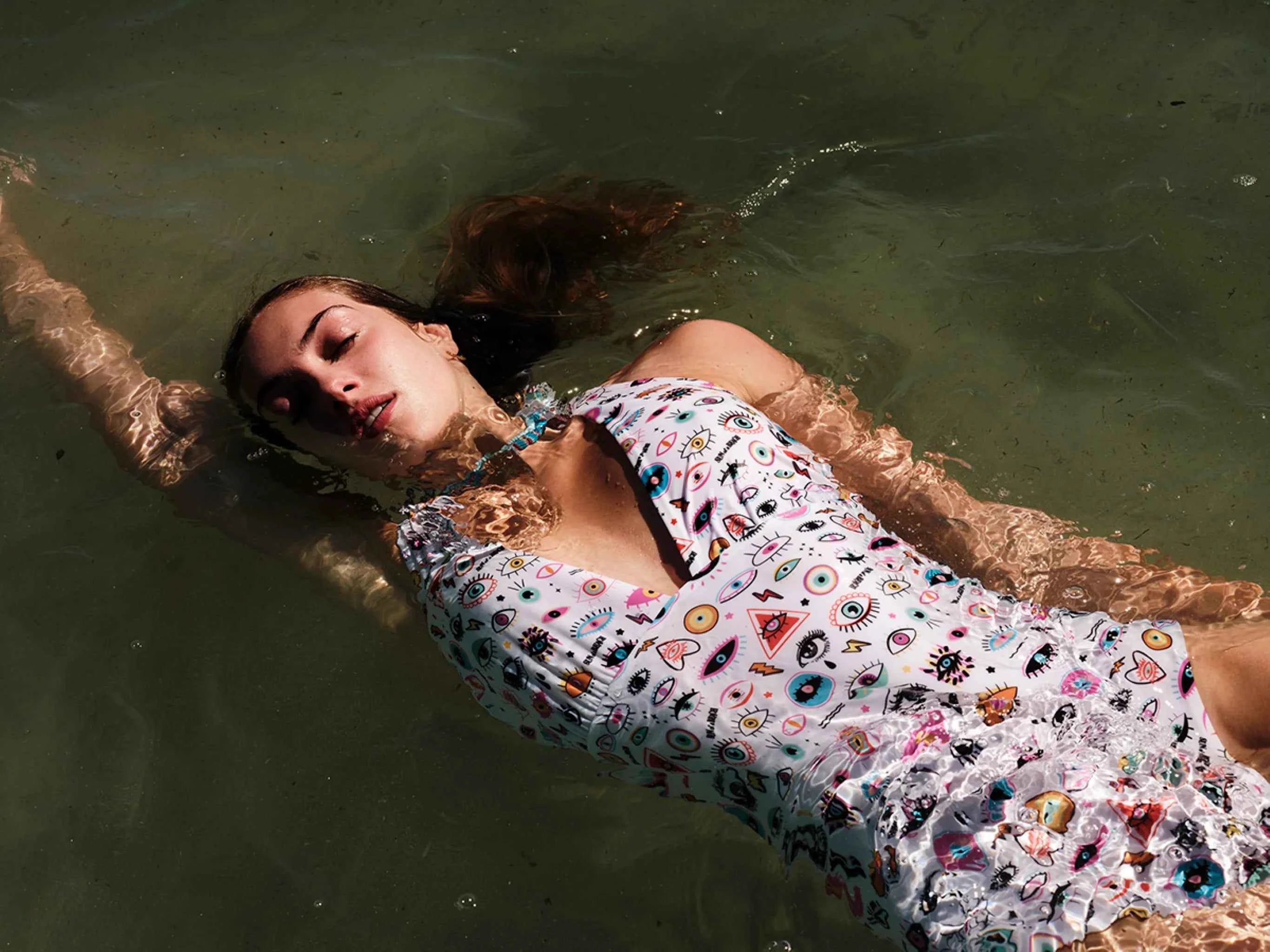 Woman in a colorful swimsuit floating in water