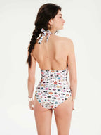 Woman wearing a patterned halter neck swimsuit on a white background