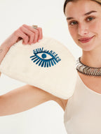 Woman holding a pouch with 'Sun of a Beach' logo on a white background