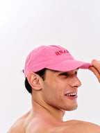 Man wearing a pink cap with text on a white background