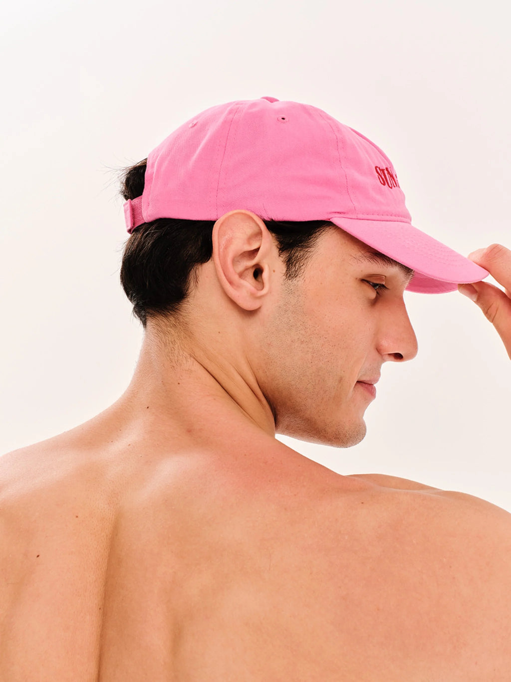 Man wearing a pink cap on a plain background
