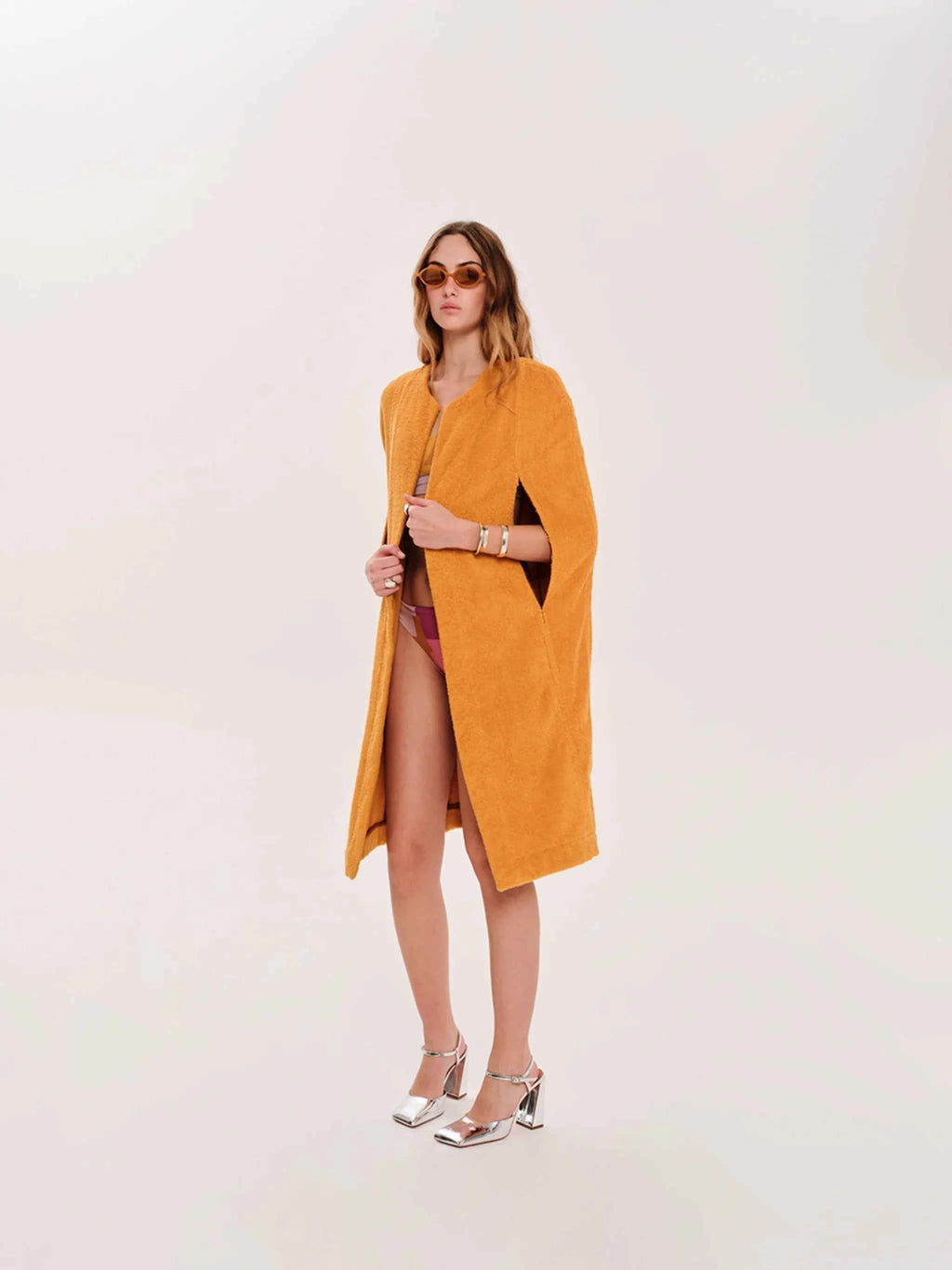 Woman wearing a mustard yellow dress with a white background