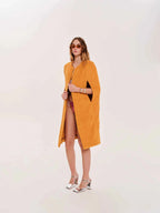 Woman wearing a mustard yellow dress with a white background