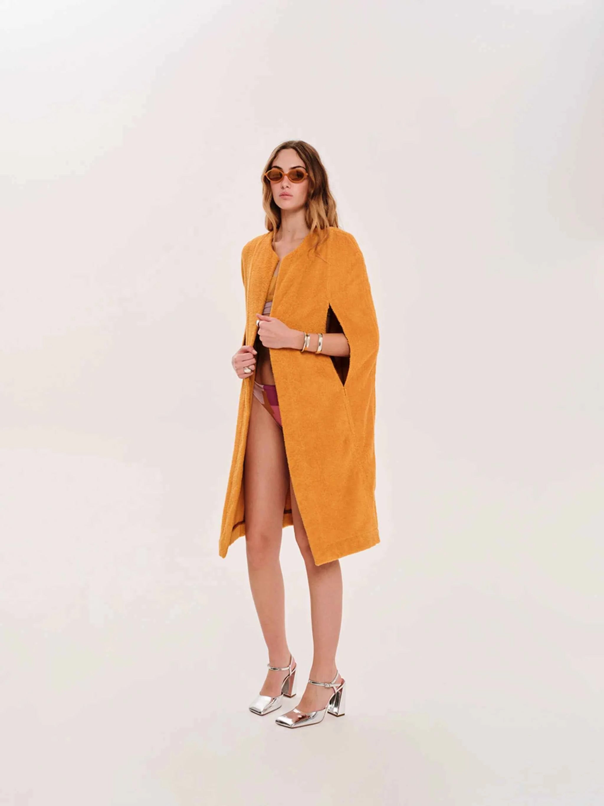 Woman wearing a mustard yellow dress with a white background