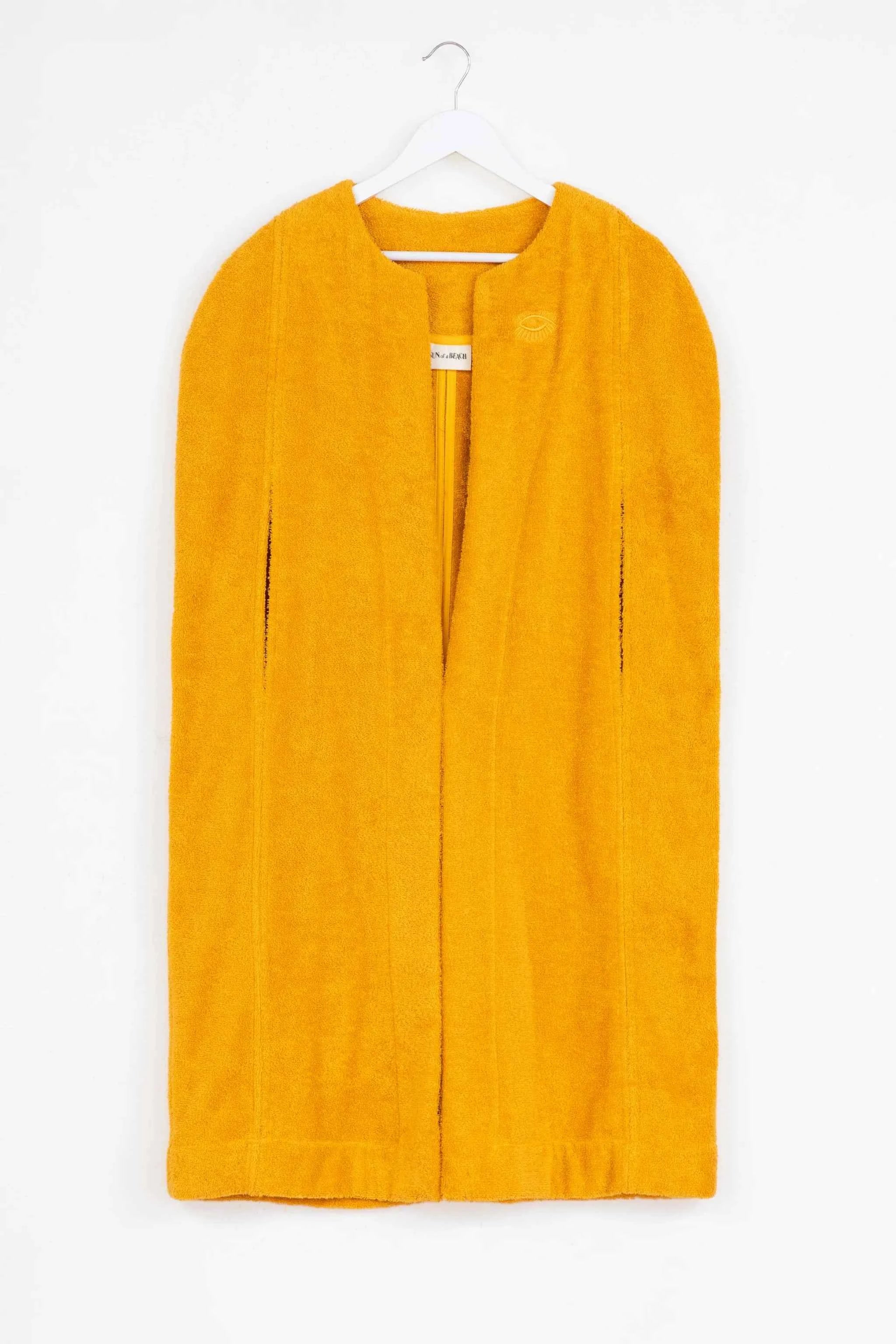 Yellow dress on a hanger against a white background