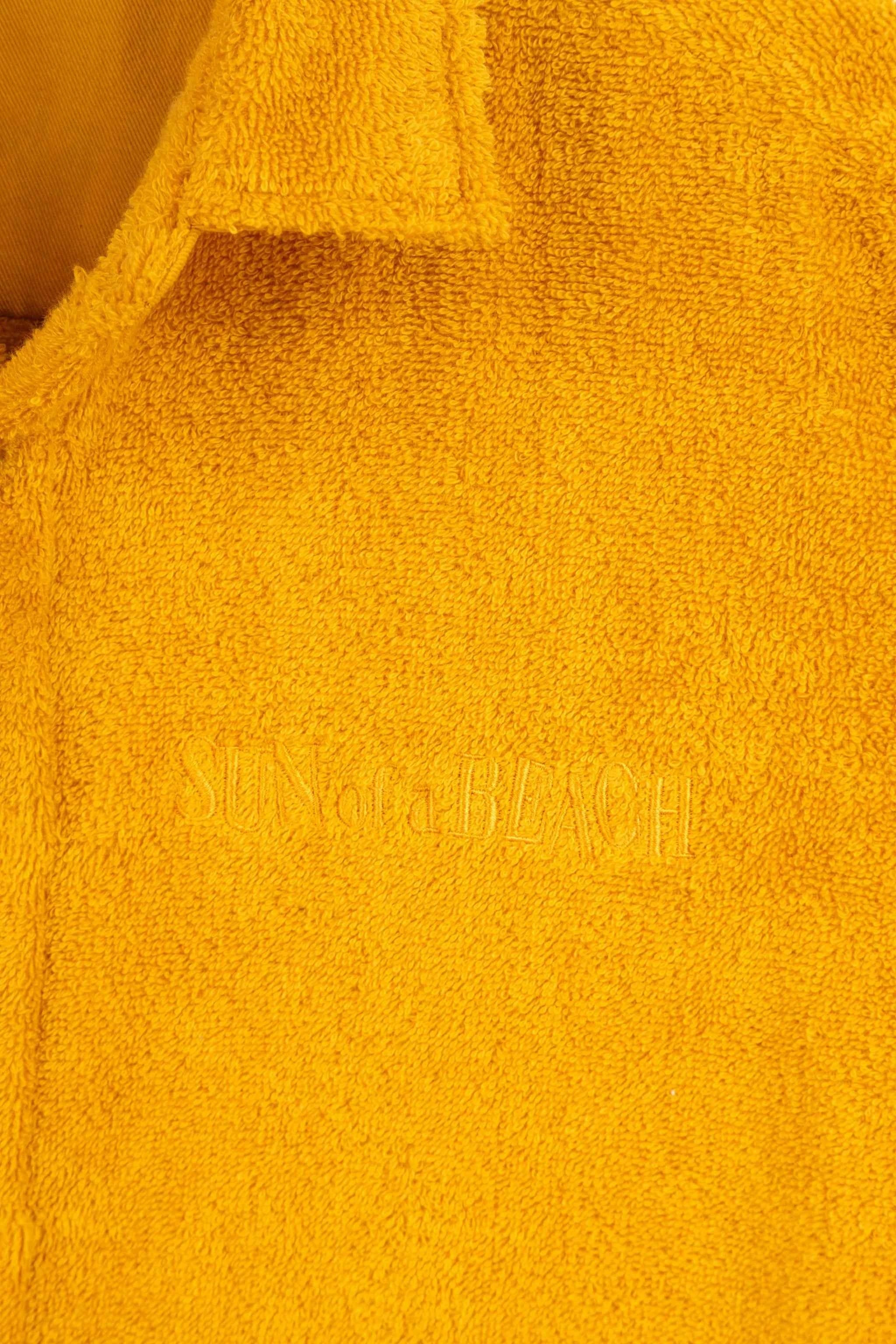 Close-up of a yellow towel with 'Made in Italy' embroidery.
