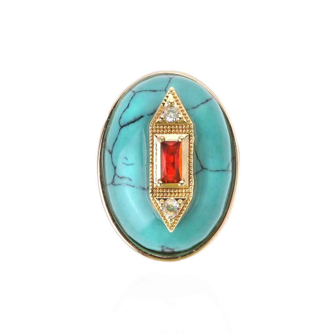 Turquoise ring with gold and red gemstone on a white background