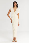 Woman wearing a white draped dress on a white background