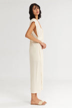 Woman wearing a white sleeveless jumpsuit on a white background