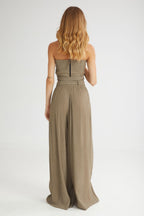 Woman wearing a strapless jumpsuit on a white background