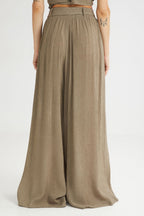 Person wearing a pair of wide-leg pants on a white background