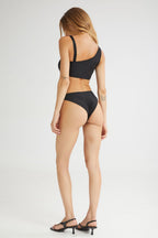 Woman wearing a black bikini set on a white background