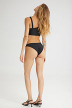 Woman wearing a black bikini on a white background