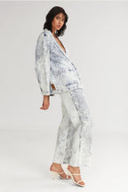Woman wearing a white and blue floral outfit on a light gray background