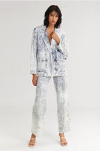 Woman wearing a white and blue patterned suit on a white background